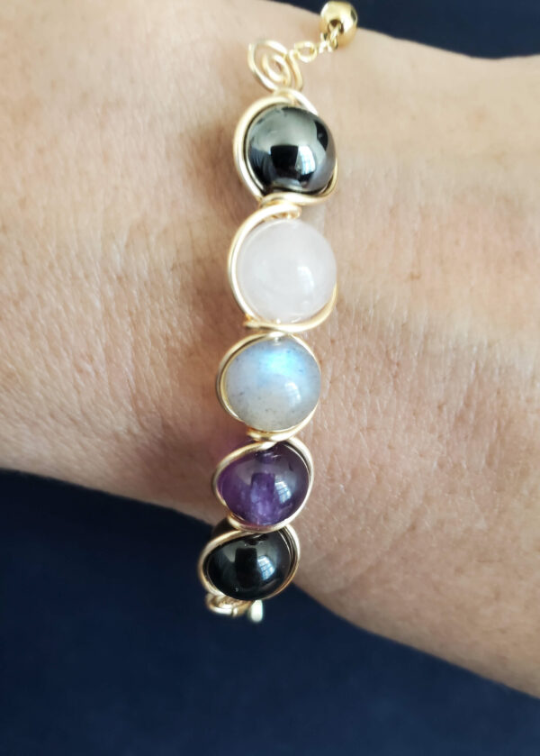 empath protection bracelet: gold tone wire wrapped with amethyst, rose quartz, labradorite, hematite, and black tourmaline.