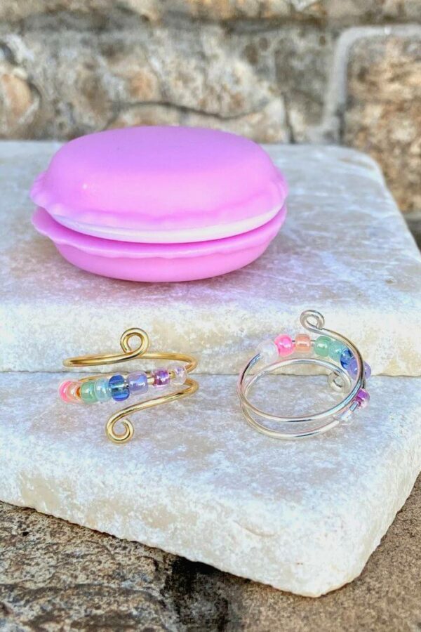 gold and silver anxiety fidget rings with pastel rainbow beads and macaron container