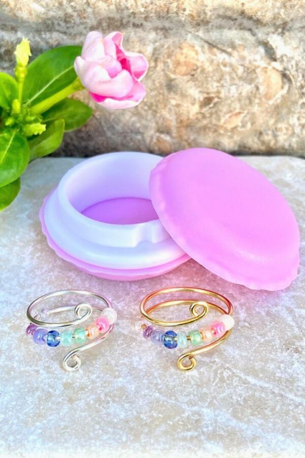 gold and silver anxiety fidget rings with pastel rainbow beads and macaron container