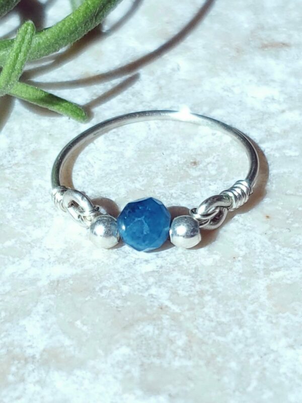 A handmade faceted apatite ring that showcases the stone's natural blue-green color and sparkling facets.