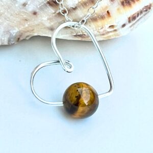 Handmade Crystal Heart Necklace featuring a Tiger's Eye gemstone for protection and confidence.